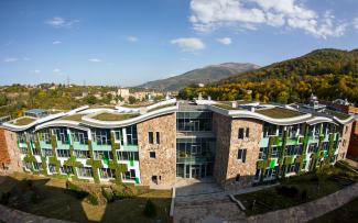 The wavelike roof gives the building an elegant appearance. © Danil Kolodin / Tim Flynn architects Gebäude mit begrünten geschwungenen Dachflächen und Fassadenbegrünung